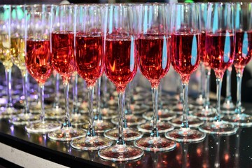 Rows of full champagne, sparkling wine and red wine glasses. Dining, drink. Catering service concept.