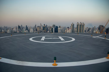 Selective focus of the Heli Copter parking lot on the deck at sunset in the capital of Thailand. Space for helicopter landing on high-rise buildings in Bangkok, Thailand.