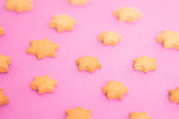 star shaped homemade cookies on a pink background