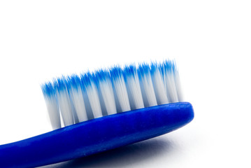 blue toothbrush with blue and white bristles. toothbrush close-up photo with copy space, isolated on white.