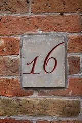 number 16 carving on brick wall