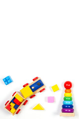 Baby kids toys background. Wooden train, stacking rings tower pyramid toy and colorful blocks. Top view, flat lay