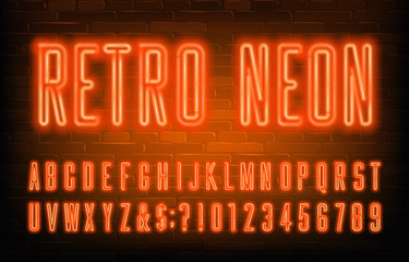 Fototapeta premium Retro Neon alphabet font. Condensed orange neon letters and numbers. Brick wall background. Stock vector typescript for your typography design.