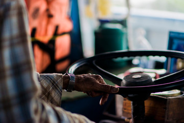 Close-up of a man driving with the steering wheel holding.