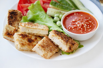 Fried tofu with fresh salad. Vegan food close up. Tofu steaks. Plantbased diet