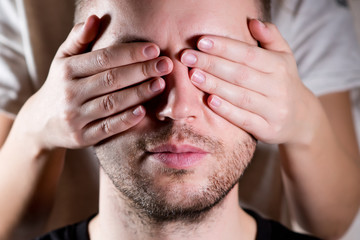 Obraz premium the woman closes her eyes to the man with her palms