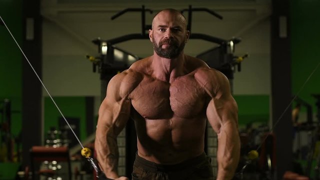 muscular bodybuilder fitness men pumping up muscles push-ups on uneven bars workout fitness exercises and bodybuilding concept background - Handsome athletic men doing bars exercises in gym naked tors