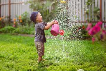 Mom and boy child water the garden together joke