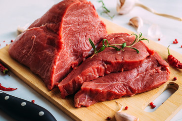 Fresh pork raw fillet on wooden board. Red beef meat on a cutting board.