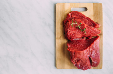 Fresh pork raw fillet on wooden board. Red beef meat on a cutting board.