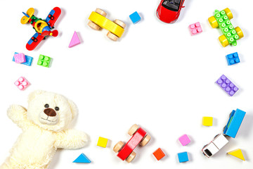 Baby kids toys frame with teddy bear, airplane, train and wooden and plastic toys on white background. Top view, flat lay. Copy space for text