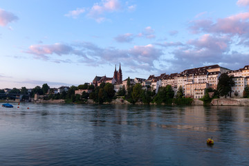 Fototapeta na wymiar Switzerland, Basel, Oberer Rheinweg, 3rd of August 2019. Panoramic view across the rhine river at the skyline of the old town of Basel during sunrise.