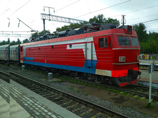 Fototapeta na wymiar ..Modern red train with cars on the railway tracks.