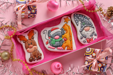 Gingerbread cookies: deer, mouse and gnome in a box on a pink background, gifts christmas or Noel holiday, horizontal orientation