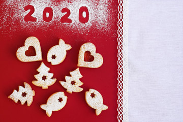 Festive Christmas or new year concept with homemade linzer cookies, red background with white lacy border, copy space for text