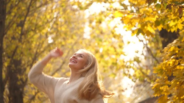 Fall outdoor. Fashionable lovable blonde woman dance laughing in autumn park. Beautiful Carefree girl in trendy fashion outfit smiling enjoy rest. Excited funny blonde portrait in park, fall concept