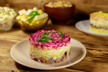 Set of festive mayonnaise salads on wooden table