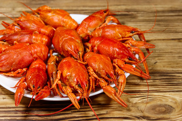 Boiled crayfish in plate on wooden table