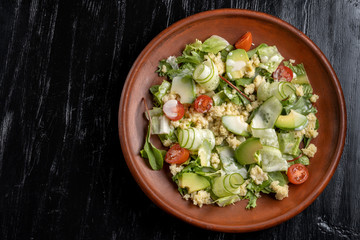 Green salad with couscous, avocado and tomato.