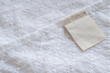 blank laundry care clothes label on fabric texture background