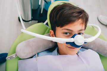 Little boy getting Inhalation Sedation while teeth treatment at dental clinic. Teeth treatment child