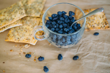 Сup with honeysuckle berries and cookies on craft paper background.