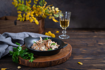 Fried chanterelle mushrooms with onion and parsley in a frying pan. Vegeterian dish. Healthy nutrition