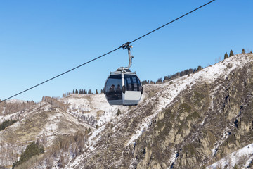 Two passengers on a cable car high in the mountains