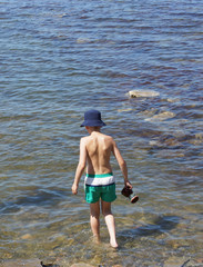 A boy in panama comes into the water.