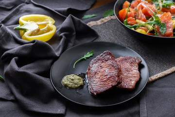 medium beef steaks with pesto sauce and vegetable salad. 