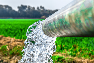 crystal clear sweet and healthy blueish water being flush out by a heavy diesel engine tube well  in the wheat fields where the river water can't reach 