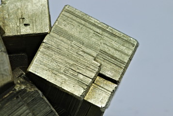 Close up detail on a cube of pyrite isolated single shiny mineral stone, fool's gold, cubic gems, on white limbo background