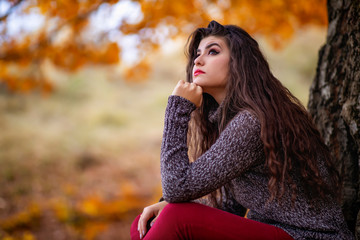 Portrait of a beautiful hispanic young woman in an autumnal forest