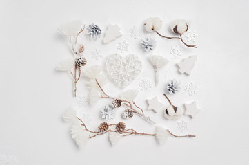 Design a Christmas greeting card with Xmas cones, heart, cotton flowers. Decorations on a white wooden background