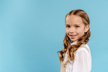 smiling and cute kid looking at camera isolated on blue