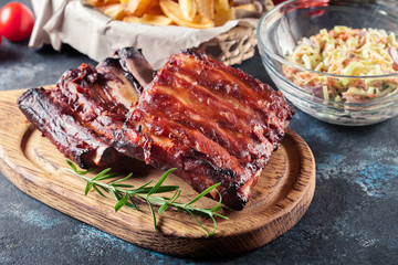 Spicy barbecued pork ribs served with BBQ sauce - obrazy, fototapety, plakaty