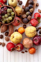 Top view to fall fruits over a white wooden background with copy space.