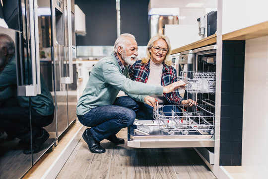 Happy Senior Husband And Wife Buying Household Appliances In Store.