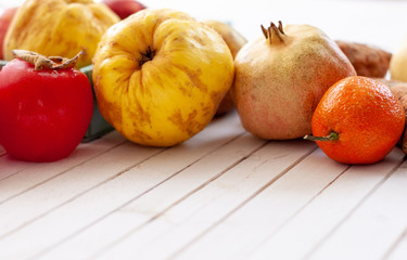 .Fall fruits close up over a white wooden background with copy space.