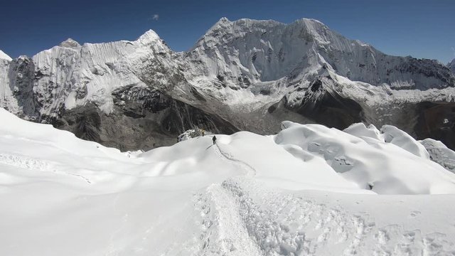 Climber summit Island Peak of the Himalayas, beautiful sunny day, track in the snow of glacier, in Himalaya, Nepal