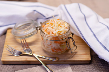 Salad sauerkraut in a glass jar on a table. Fermented foods. Vegetarian food.