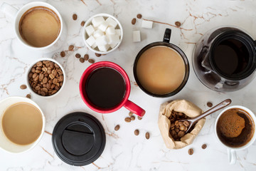 Different types of coffee in cups on dark table, top view