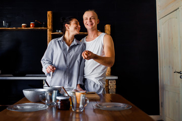 Young couple in love cooks together in a kitchen. A guy and a girl spend time together in a new apartment. Housewarming.