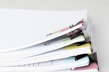 Stack of old office working document with pastel note paper and paper clip folder on white...