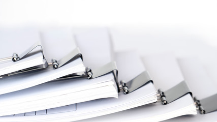 Stack of white office working document with black paper clip folder on white background