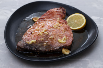 fried tuna with salt and lemon on dark plate