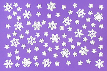 Top view of white snowflakes on colorful background. Winter weather concept with copy space. Merry Christmas concept