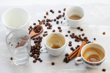 empty cups of coffee with milk and grains on ceramic background
