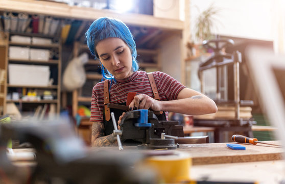 Confident young craftswoman in her workshop