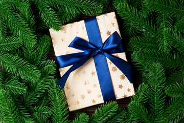 Top view of Christmas gift box on fir tree background. Time for holiday concept with copy space